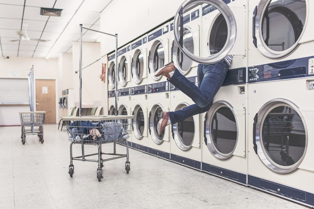 personne attrapant du linge dans la machine à laver